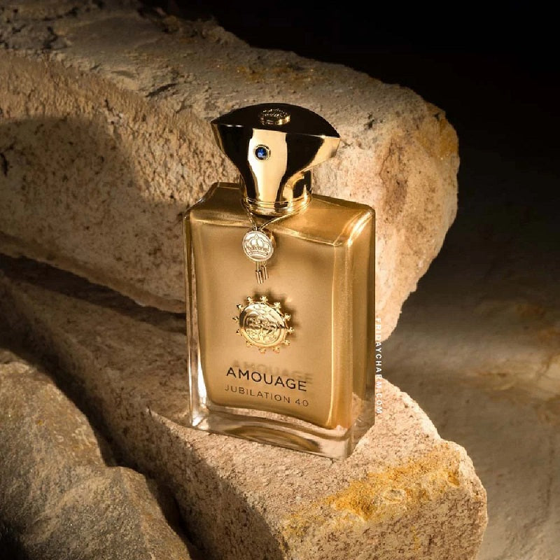 Gold Amouage Jubilation 49 perfume bottle on stone surface