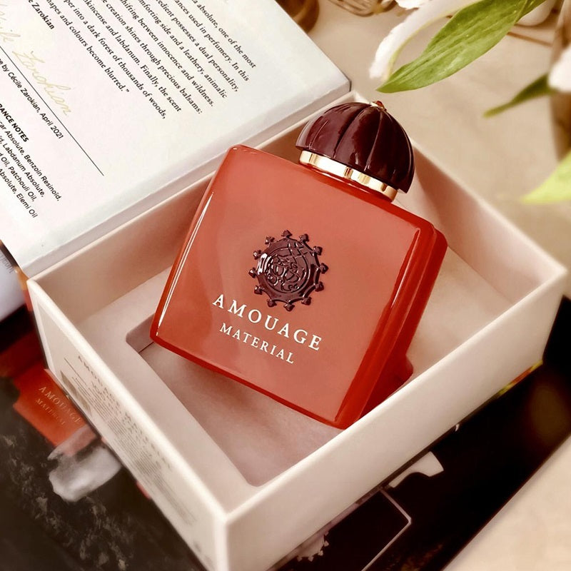 Red Amouage perfume bottle in a box with a blurred background