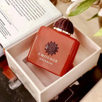 Red Amouage perfume bottle in a box with a blurred background