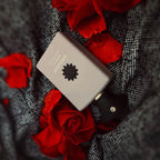 Close-up of Amouage Opus VII Reckless Leather perfume bottle showcasing Red roses and bottle