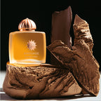 Amouage perfume bottle on a textured brown surface with a dark background