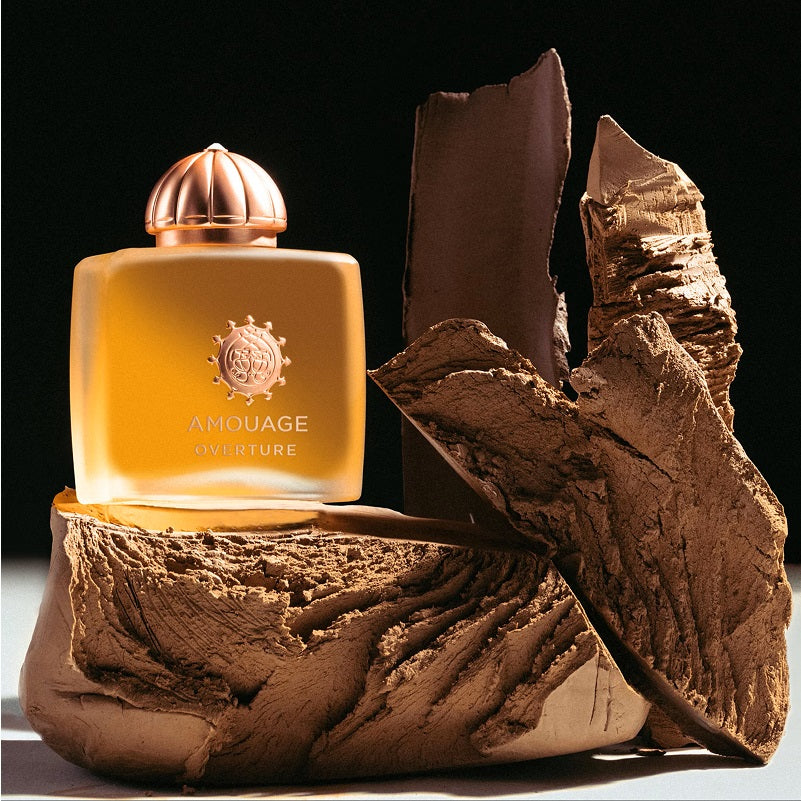 Amouage perfume bottle on a textured brown surface with a dark background
