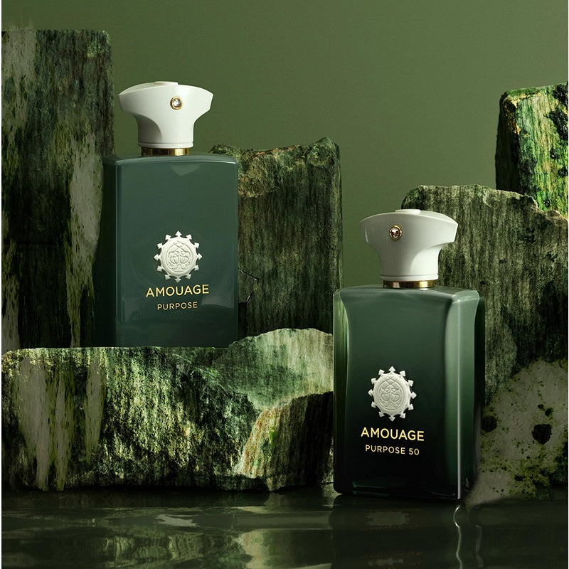 Two green Amouage Purpose perfume bottles on a textured green background