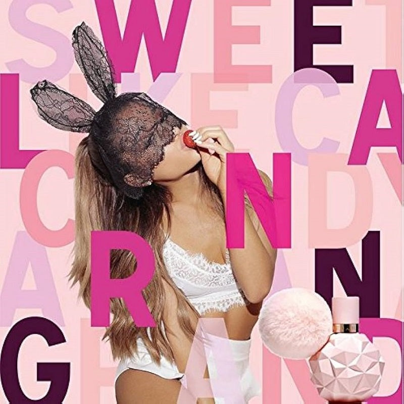 Person in lingerie with bunny ears and a perfume bottle against a colorful text background