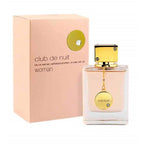 A product image showing a box and bottle of Club de Nuit Woman Eau De Parfum by Armaf. The box is pink with a gold circle design, and the bottle is clear with a gold cap and a label that reads 'Club de nuit woman'.