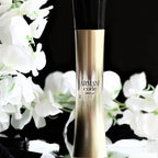 Armani Code Absolu perfume bottle with white flowers on a black background