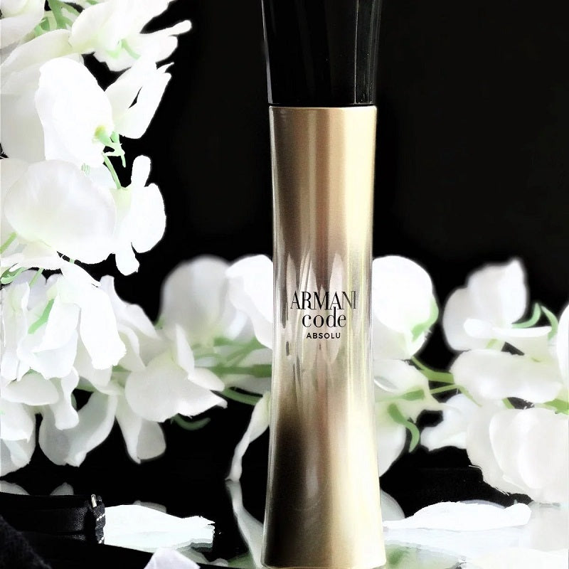 Armani Code Absolu perfume bottle with white flowers on a black background