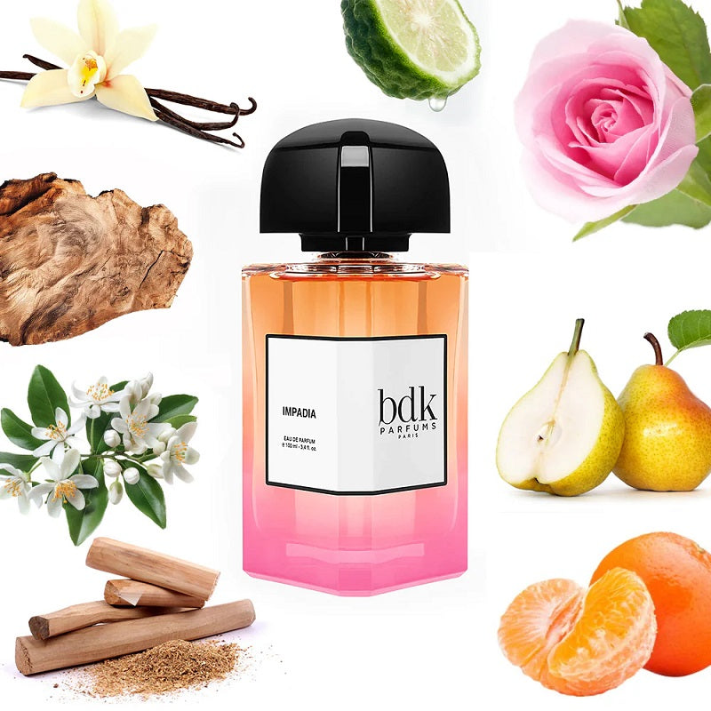 Bottle of bdk Parfums with floral, fruit, and spice elements on a white background