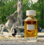 Boucheron perfume bottle in a park setting with sculptures in the background