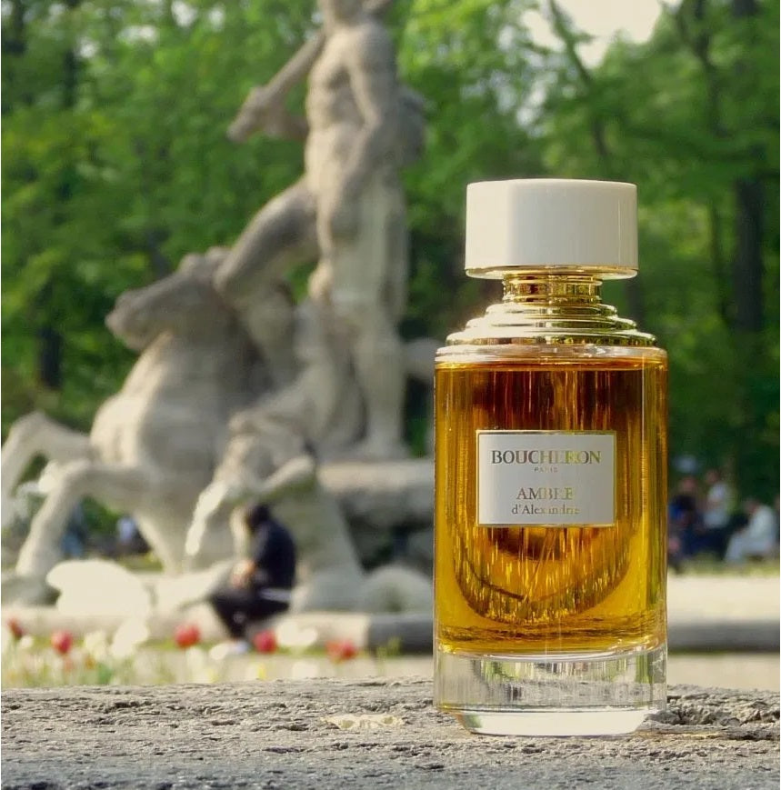 Boucheron perfume bottle in a park setting with sculptures in the background