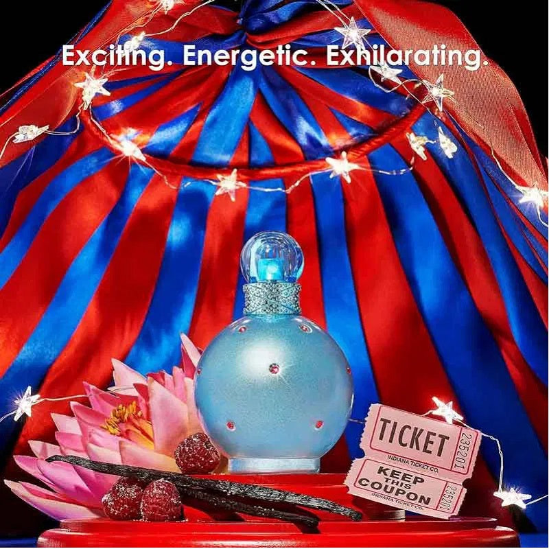 Blue perfume bottle with red and blue fabric, flowers, and a ticket on a dark background