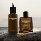 Two Burberry Hero perfume bottles on a rock with a blurred ocean background