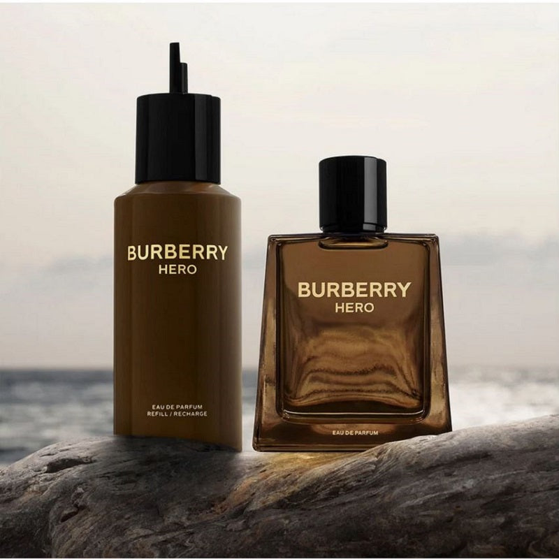 Two Burberry Hero perfume bottles on a rock with a blurred ocean background