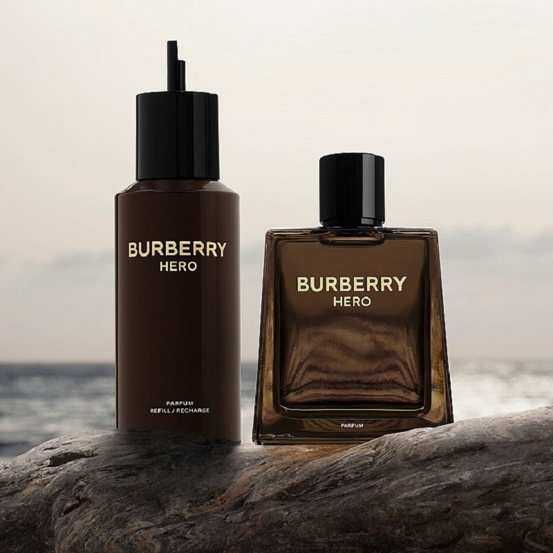 Two Burberry Hero perfume bottles on a rock with a blurred ocean background.