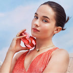 Lifestyle Image: Omnia Coral 100 ml Eau de Toilette by Bvlgari – captured in a sunlit coastal setting evoking joy, elegance, and radiant summer energy.