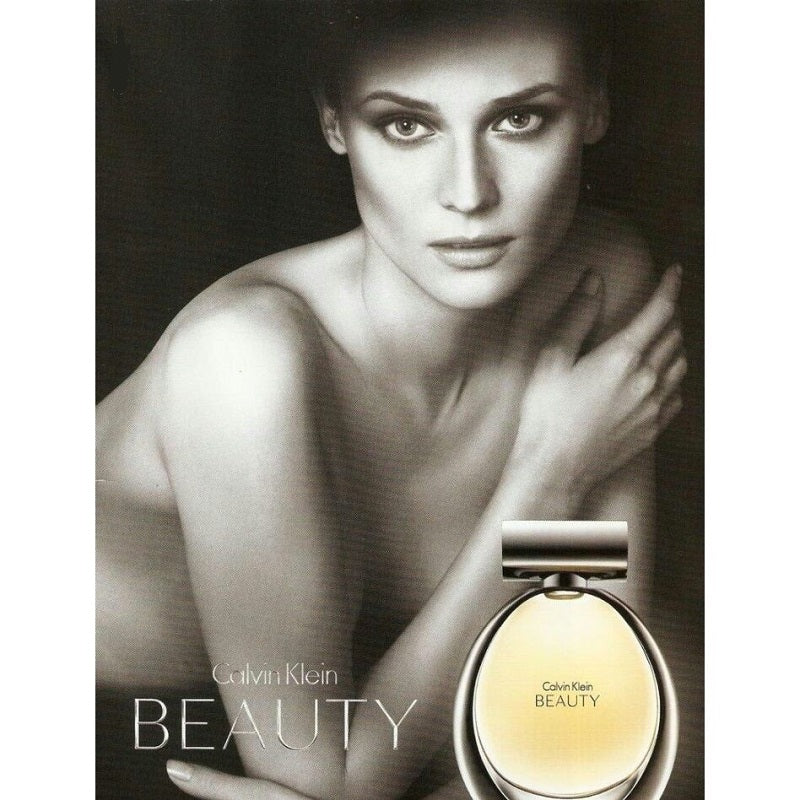 Beautiful model laying on the floor behind a bottle of calvin klein beauty E DP
