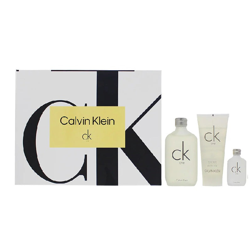 Calvin Klein gift set featuring a large patterned box with a yellow label, alongside three matching toiletry bottles and tubes in frosted white and light gray.