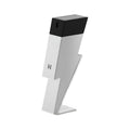 A chrome bottle of Bad Boy Superstars Eau de Toilette by Carolina Herrera, with a black cap, positioned on a stand.