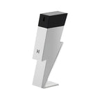 A chrome bottle of Bad Boy Superstars Eau de Toilette by Carolina Herrera, with a black cap, positioned on a stand.