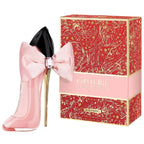 Pink high-heeled shoe-shaped perfume bottle with a bow and matching box on a white background