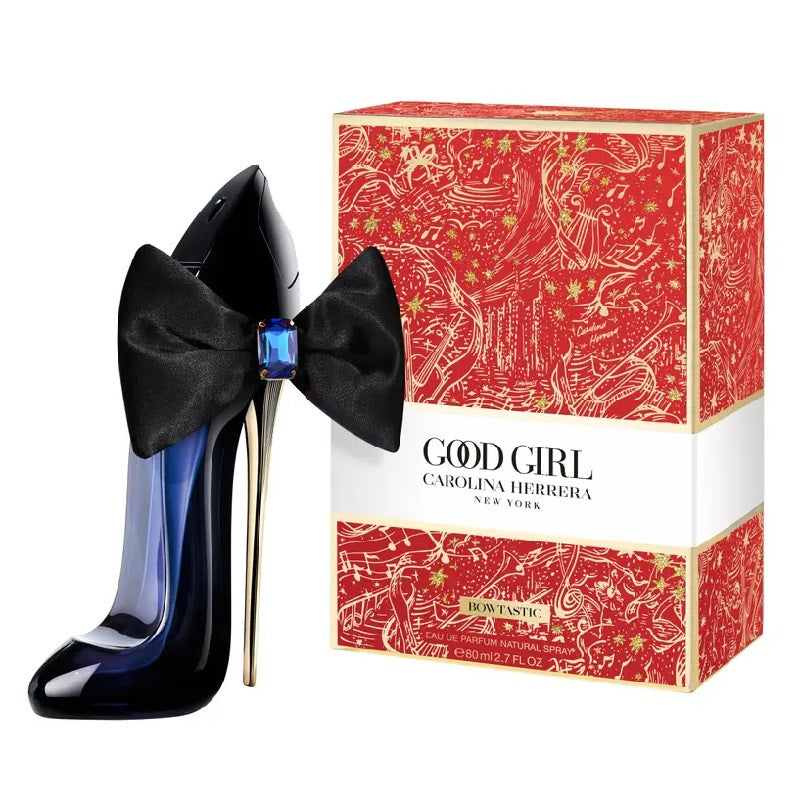 Black high-heeled shoes with a bow and Carolina Herrera 'Good Girl' perfume box on a white background