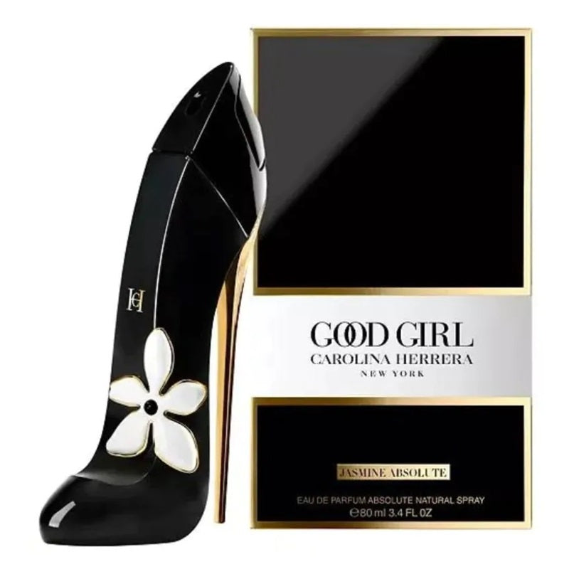 Carolina Herrera Good Girl Jasmine Absolue perfume bottle designed like a high-heeled shoe in glossy black with a white flower motif, shown next to its black and gold retail box on a white background.