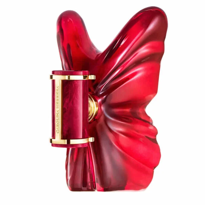 Carolina Herrera Red Orchid perfume bottle with a glossy, sculptural red orchid flower design and gold trim, shown on a solid white background.