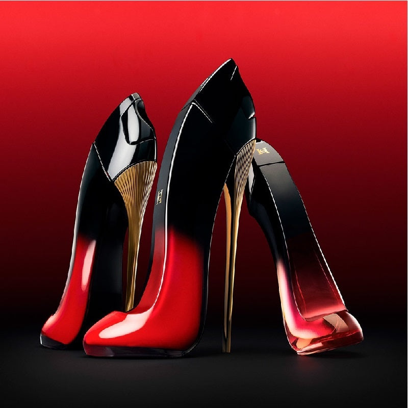 Black high-heeled shoes with red soles on a red background