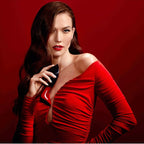 Woman in a red dress holding a phone against a red background