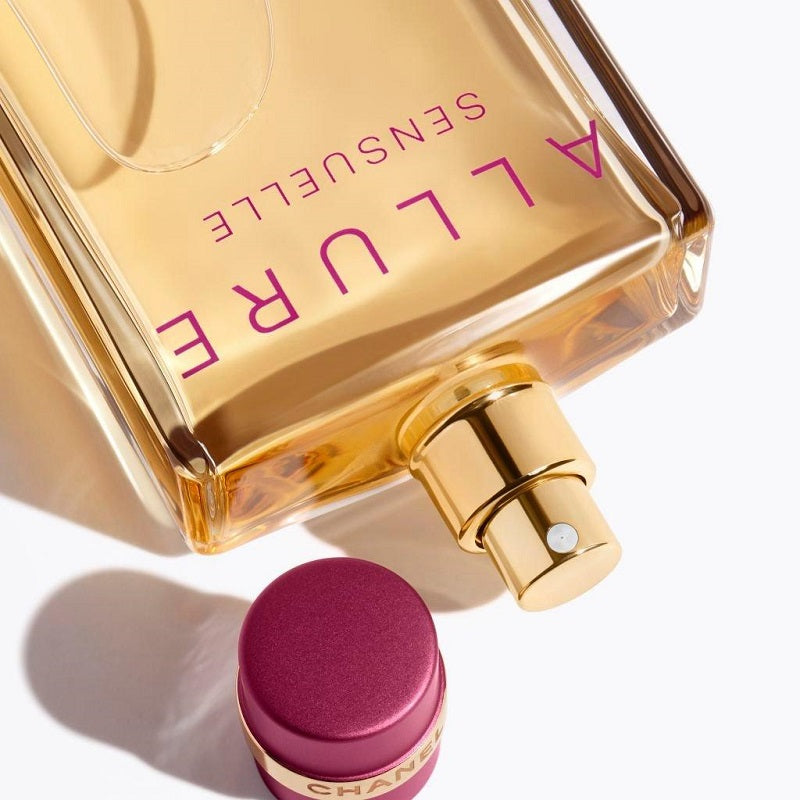 Chanel Allure Sensuelle perfume bottle with gold cap and pink label on a white background