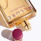 Chanel Allure Sensuelle perfume bottle with gold cap and pink label on a white background