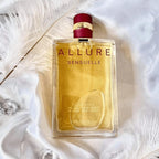 Perfume bottle labeled 'ALLURE Sensuelle' on a white feather background
