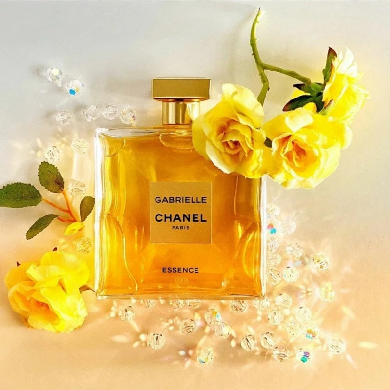 Chanel perfume bottle with yellow flowers on a light background