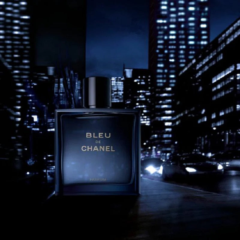 Bleu de Chanel perfume bottle against a city skyline at night