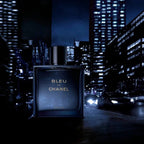 Bleu de Chanel perfume bottle against a city skyline at night