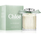 A bottle of Chloe Naturelle Eau de Parfum with its packaging box, both featuring a light green color. The perfume bottle is transparent, showcasing the light-colored liquid inside.