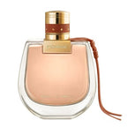 A bottle of Nomade Absolu Eau de Parfum by Chloe, with a clear glass container, a gold cap, and a brown leather strap.