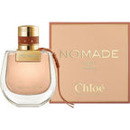 A product image featuring Nomade Absolu Eau De Parfum by Chloe in a glass bottle with a gold cap, alongside its packaging box.