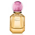 Chopard Happy Bigaradia perfume bottle with a faceted gold glass body and a round translucent pink cap, shown on a white background.