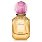 Chopard Happy Bigaradia perfume bottle with a faceted gold glass body and a round translucent pink cap, shown on a white background.