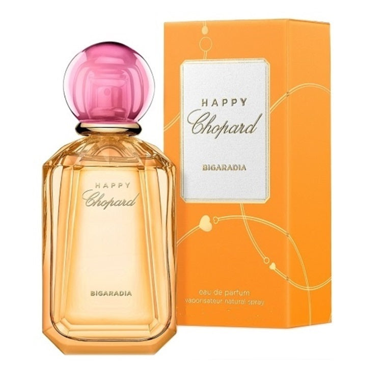 Chopard Happy Chopard Bigaradia eau de parfum bottle with a pink spherical cap next to its orange packaging box.