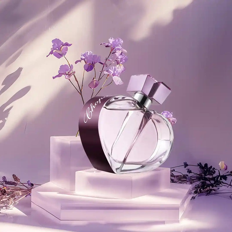 Perfume bottle with purple flowers on a light background