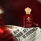 Clive Christian perfume bottle on a newspaper with a dark background