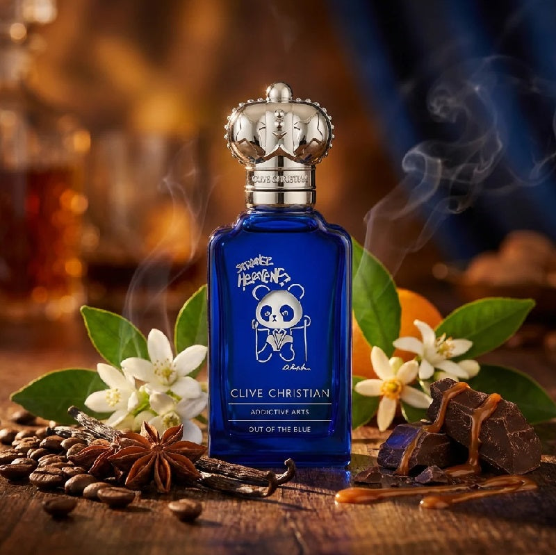 Blue Clive Christian perfume bottle with floral and aromatic elements on a wooden surface