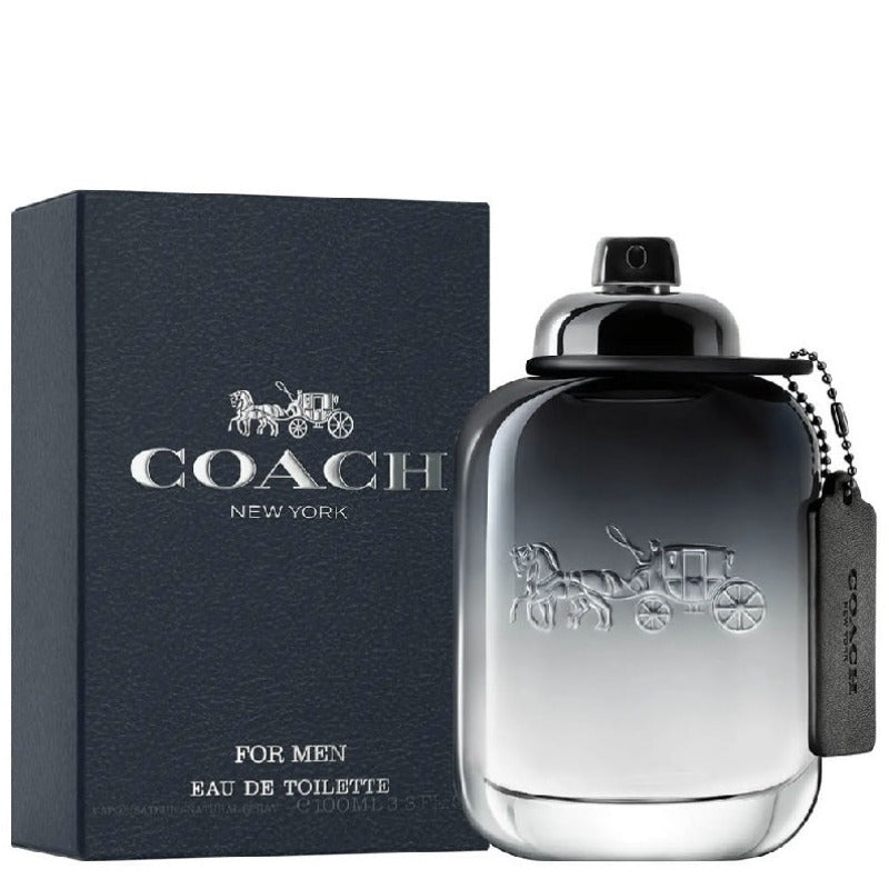A square-shaped Coach Men's Eau de Toilette bottle with a silver cap, next to its blue packaging box. The box has the Coach brand logo and 'NEW YORK' printed on it.