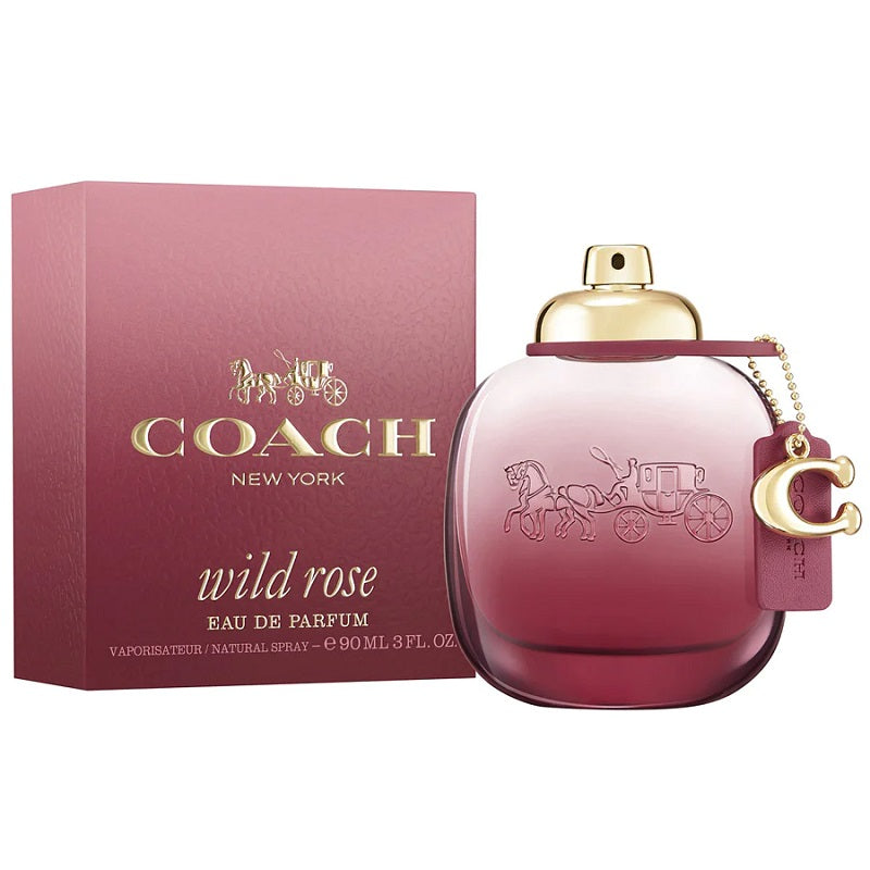 A Coach Wild Rose Eau de Parfum bottle with a gold cap, next to its pink packaging box featuring the Coach logo.