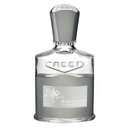 A bottle of Creed Aventus Cologne eau de parfum with a white label and decorative elements, transparent bottle showcasing the liquid inside.
