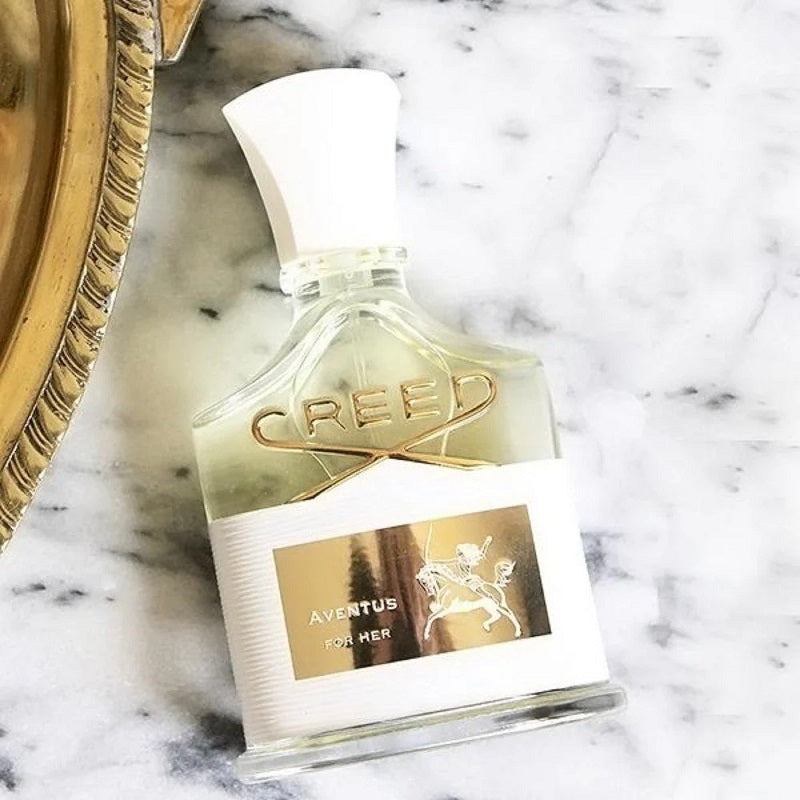 Creed Aventus for Her perfume bottle on a marble surface