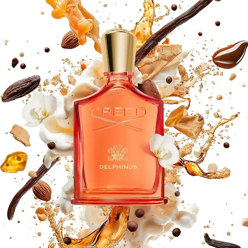 Creed Delphinus perfume bottle surrounded by vanilla beans, flowers, and other elements on a white background