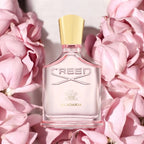 Creed Eladia perfume bottle on pink flowers